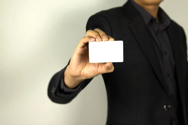 Business Man wearing smart suit and holding whit ID card in his hand, A smart man holding white mock up card, used in card design poster.