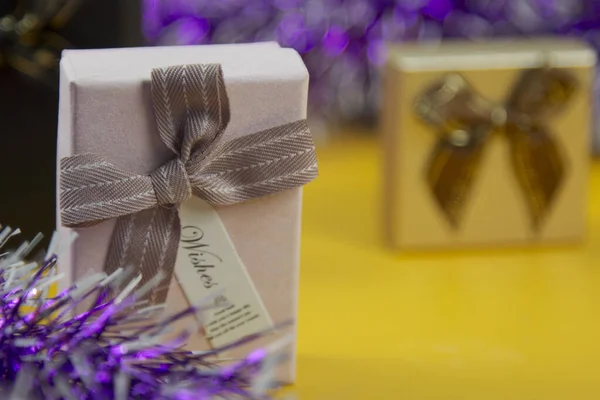 Schöne Geschenkboxen Auf Gelbem Hintergrund Und Umgeben Von Bunten Bändern — Stockfoto