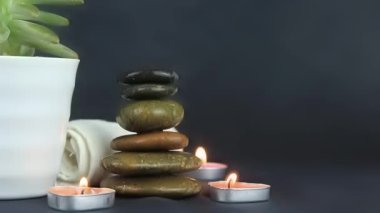 Two burning wax candles, with small stones in the dark use for relaxing time and yoga elements.