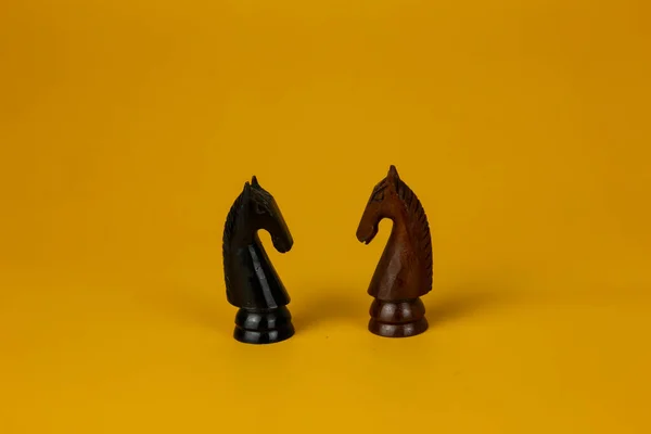 Dwa Konie Zwrócone Przodem Siebie Walki Pionek Szachowy Izolowane Żółte — Zdjęcie stockowe