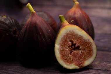 Figs lie on the board, 3 figs, brown background, delicious fruits, juicy figs