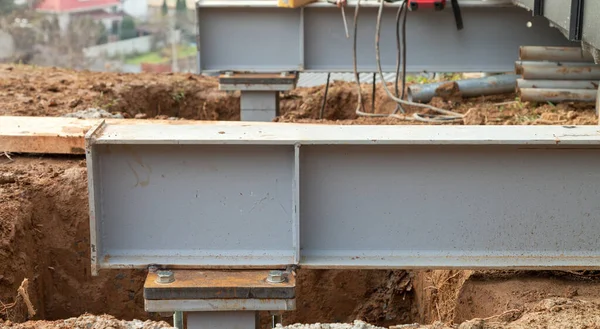 Concrete foundations support metal columns. The house is installed on metal structures