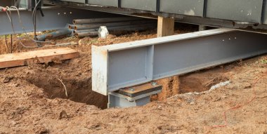 Concrete foundations support metal columns. The house is installed on metal structures