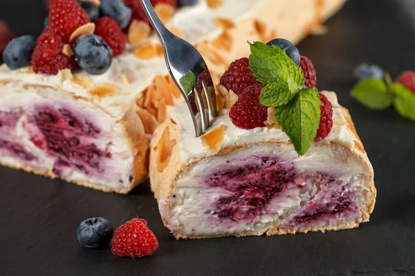 Meringue roll with raspberry berries, pigeons and mint leaves