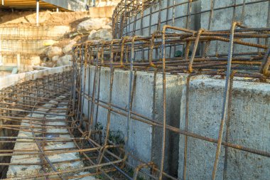 İnşaat sırasında beton bloklara metal takviye ekleniyor. İnşaat alanındaki beton bloklar metal takviyesiyle güçlendirilebilir.