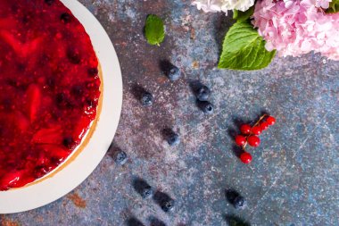 Taze çilekli cheesecake, kırmızı frenk üzümü ve yabanmersini. Ev yapımı peynirli turta. Üst görünüm