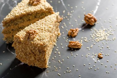 Cevizli ve haşhaşlı kek. Koyu arkaplanda dilimlenmiş kek parçaları.