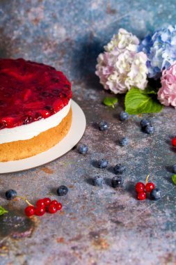 Taze çilekli cheesecake, kırmızı frenk üzümü ve yabanmersini. Ev yapımı peynirli turta.