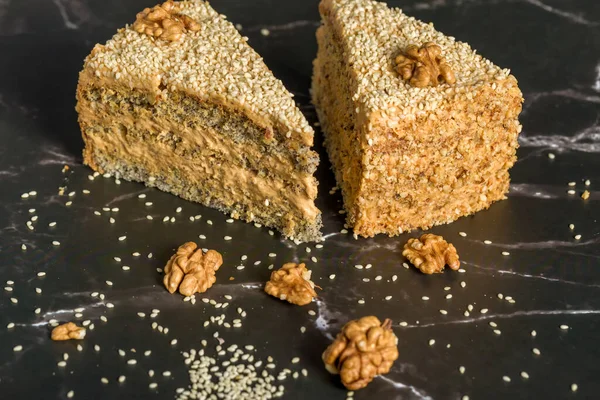 Walnut and poppy seed cake. Sliced pieces of cake on a dark background