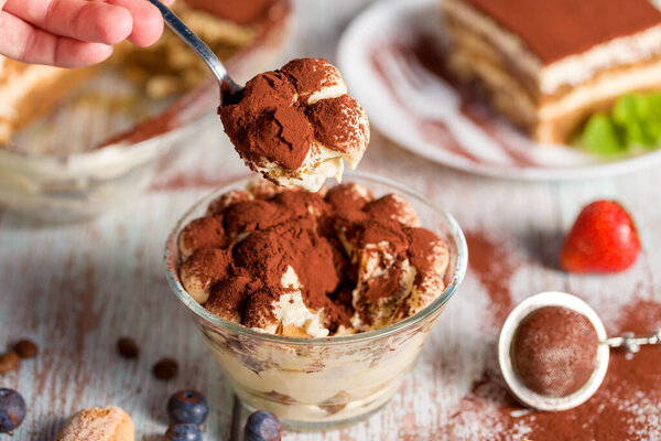 Tiramisu dessert. Delicious Italian dessert on a glasses with a sprig of mint. Side view