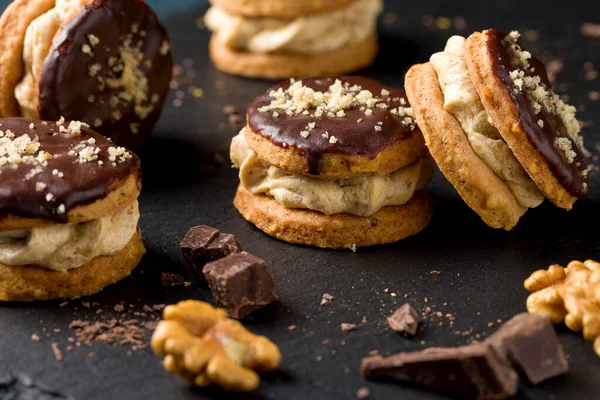 Round nut cookies with coffee and nut cream. Delicious dessert with chocolate, hazelnut praline and coffee