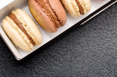 Siyah bir karton kutunun içinde siyah bir arka planda makaronlar..