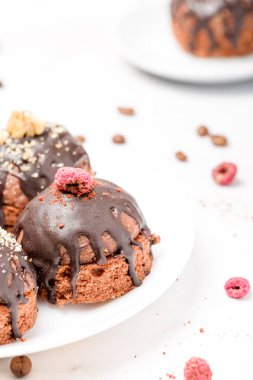 Yuvarlak çikolatalı kek. Şekerli ahududu ile süslenmiş. Hafif arkaplan.