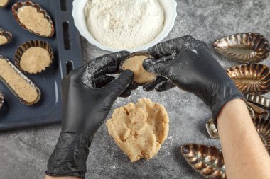 Hamur oluşumu. Metal şekilli. Hamur işi şefi hamur işlerini pişirmek için metal kalıpların içine koyar.