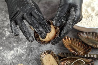 Hamur oluşumu. Metal şekilli. Pasta şefi hamur işini pişirmeye hazırlanmak için metal kalıplara döker.