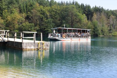 PLITVICE, CROATIA - SEPTEMBER 13, 2016: Kimliği belirsiz bir turist grubu Plitvice Gölleri Ulusal Doğa Koruma Alanı 'nda Kozjak Gölü' nden elektrikli feribotla geçirildi.