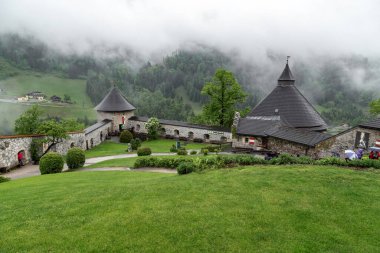 WERFEN, AUSTRIA - 20 Mayıs 2019: Bu Hohenwerfen Kalesi 'nin alt avlusunun ve Doğu Alpleri' nin eteklerinin yağmurlu bir günde çevreleyen yamaçlarının manzarası..