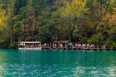PLITVICE, CROATIA - 13 EPTEMBER 2016: Kimliği belirsiz kişiler Plitvice Gölleri Ulusal Doğa Koruma Alanındaki Kozjak Gölü 'nden geçen bir elektrikli feribota biniyor.