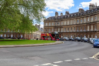 BATH, GREAT BRITAIN - 14 Mayıs 2014: Tur otobüsü sirk meydanından ikonik tarihi eğimli konak evleri ile geçer.