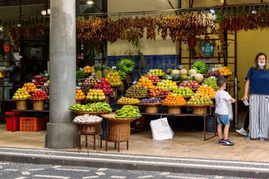 FUNCHAL, PORTUGAL - AUGUST 24, 2021: This is a stall at the Farmers Market teeming with tropical fruits.