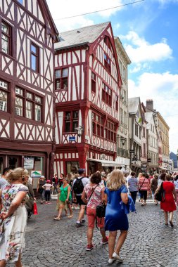 ROUEN, FRANCE - AUGUST 31, 2019: Unidentified tourists inspect the ancient half-timbered architecture of the medieval streets of the city.