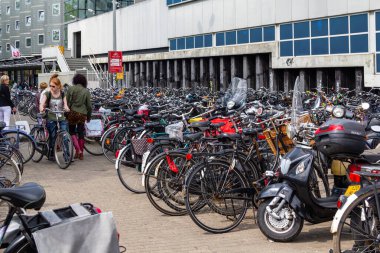 AMSTERDAM, NETHERLANDS - MAY 5, 2013: An unidentified cyclist is looking for a place to park her bike in the city center.