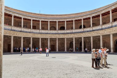GRANADA, SPAIN - MAY 20, 2017: Unidentified visitors inspect the courtyard of the Palace of Carlos V in the Alhambra.