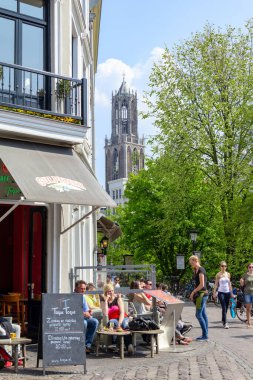 UTRECHT, NETHERLANDS - MAY 6, 2013: Unidentified residents are enjoying themselves in a small cafe in the old city center in the early morning.