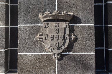 FUNCHAL, PORTUGAL - AUGUST 20, 2021: This is a fragment with a relief with the coat of arms of Portugal on the pedestal of the Statue Infante.