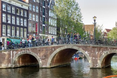 AMSTERDAM, NETHERLANDS - MAY 4, 2013: This is one of the old stone arched bridges over the canals in the historical center of the city.