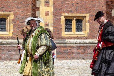 HAMPTON, GREAT BRITAIN - 18 Mayıs 2014: Bunlar, Kral VIII. Henry ve Kardinal Thomas Wolsey karakterlerinde tanımlanamayan ziyaretçilerle Hampton Sarayı 'nda yürüyüş yapan kimliği belirsiz sanatçılar..