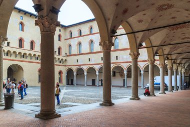 MILAN, ITALY - 10 Mayıs 2018 Sforza şatosunun içindeki ortaçağ Rocchetta kalesinin avlusundaki kimliği belirsiz turistler..