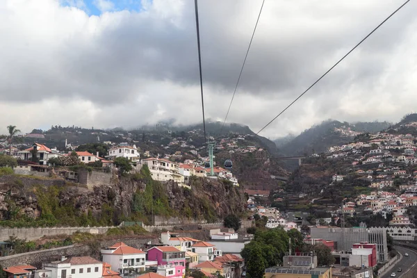 stock image FUNCHAL, PORTUGAL - AUGUST 24, 2021: This is a cable car along the side of a mountain with urban areas hidden in the clouds.