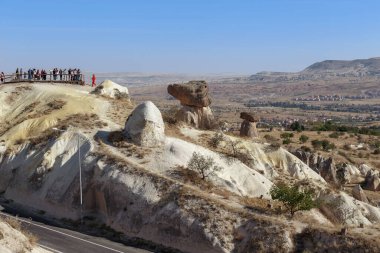 URGUP, TURKEY - 4 Ekim 2020 Kapadokya Vadisi 'ndeki Three Sisters kayalıklarında bir yol kenarı gözlem güvertesi.