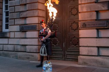 Edinburgh, İngiltere - 10 Eylül 2014: Ulusal kostümlü kimliği belirsiz bir sokak sanatçısı, bir gece şehrinde ateşle gösteri yapıyor.