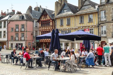 QUIMPER, FRANCE - 6 EPTEMBER 2019: Kimliği belirlenemeyen insanlar, ortaçağ yarı keresteli evlerle inşa edilmiş, eski şehrin meydanlarından birinde dinleniyorlar..