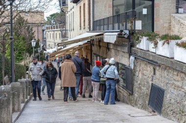 SAN MARINO, SAN MARINO - 11 MARTH 2023: Şehrin eski caddelerinden birinin önünde turist ürünleri satan çok sayıda mağazası olan bir sürü kimliği belirsiz turist.