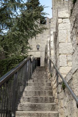 SAN MARINO, SAN MARINO - 11 MARTH 2023: Bu, dağ yamacında yer alan kale duvarı boyunca kuleler arasında bir merdiven.