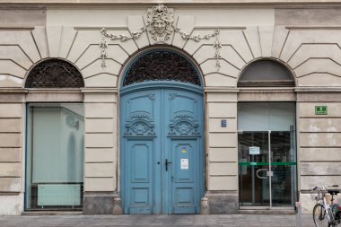 LJUBLJANA, SLOVENIA - MARTH 7, 2023: Bu, üzerlerinde ahşap kapılar ve dekoratif süslemeler bulunan eski bir barok evin ön cephesinin bir parçası.