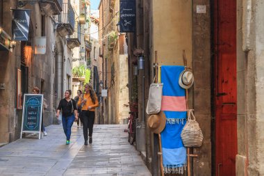 BARCELONA, SPAIN - 10 Mayıs 2017: Kimliği belirsiz turistler Gotik Mahallenin dar sokaklarında küçük kafeler ve hediyelik eşya dükkanlarıyla dolaşıyorlar.