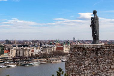 BUDAPEST, HUNGARY - 14 MARTH 2023 Tuna boyunca şehir manzarası ve Buda Tepesi 'nde İsa ile Bakire Meryem heykeli.