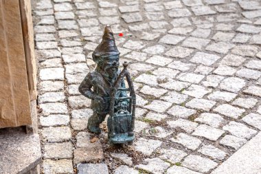 WROCLAW, PALAND - 11 Kasım 2023: Bu sembolik bronz bir şehir caddesinde bagajı olan bir cüce gezginin heykeli..