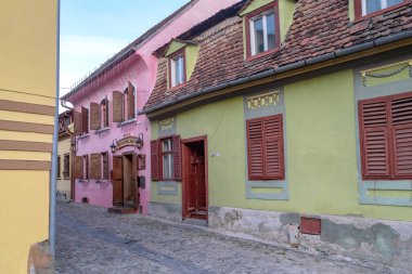 SIGHISOARA, ROMANIA - 2 Mayıs 2023: Bu iyi korunmuş, iyi korunmuş eski evleri ile kalenin ortaçağ yerleşim sokaklarından biri.