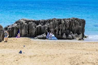 PORTO SANTO, PORTUGAL - 26 Ağustos 2021: Bunlar Ponta da Calheta Burnu 'ndaki kumlu sahildeki tuhaf kayaların yakınındaki tanımlanamayan tatilciler..