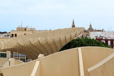 SEVILLE, SPAIN - MAY 21, 2017: This is a fragment of the Metropol Parasol, a modern architectural structure made of concrete and wood in the old quarter of the city. clipart