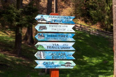 PUTNA, ROMANIA - 30 Nisan 2023: Turistik yerler için yön işaretleri içeren bir sütun.