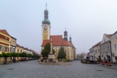 KOSZEG, HUNGARY - 18 Mayıs 2024: Bu, sisli sonbahar sabahında St. Imre Kilisesi ile Jurisiç Meydanı 'nın manzarası.