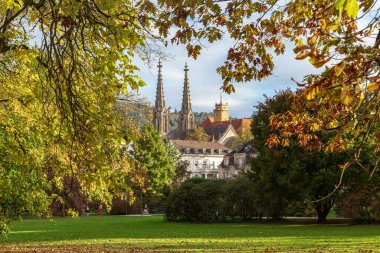 BADEN-BADEN, GERMANY - 28 Ekim 2024: Bu Lichtentaler Allee parkından Evanjelik Kilisesi ve şehir binalarına doğru bir manzara.
