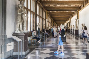 FLORENCE, İtalya - 18 Eylül 2018: Tanımlanamayan turistler Uffizi Galerisi 'nin koridorlarında sergilenen sanat eserlerini görüyorlar.