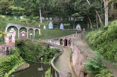 FUNCHAL, PORTUGAL - 24 AĞUSTOS 2021 Burası Monte Tropikal Parkı 'ndaki yapay Central Lake yakınlarında yaya geçitleri olan bir park..